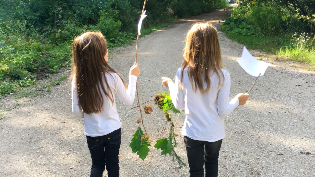 Bei einer anderen Aufgabe der Wald-Schatzsuche basteln die Kinder ein Mobile aus Blättern und Zweigen